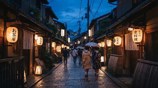 A lantern-lit cobblestone street in Kyoto at dusk.